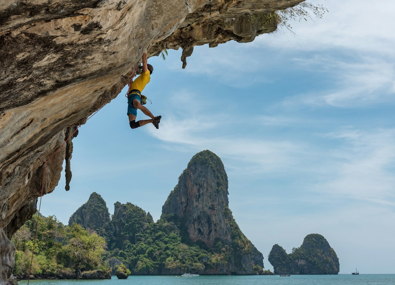 Escalador en una pared de roca junto al mar, fotografía de Hu Chen
